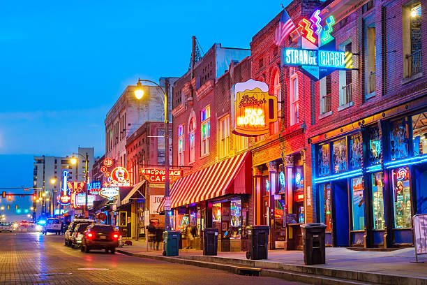 Photo of colorful cafe bars at the iconic Beale Street music and entertainment district of downtown Memphis, Tennessee, USA, illuminated at night.